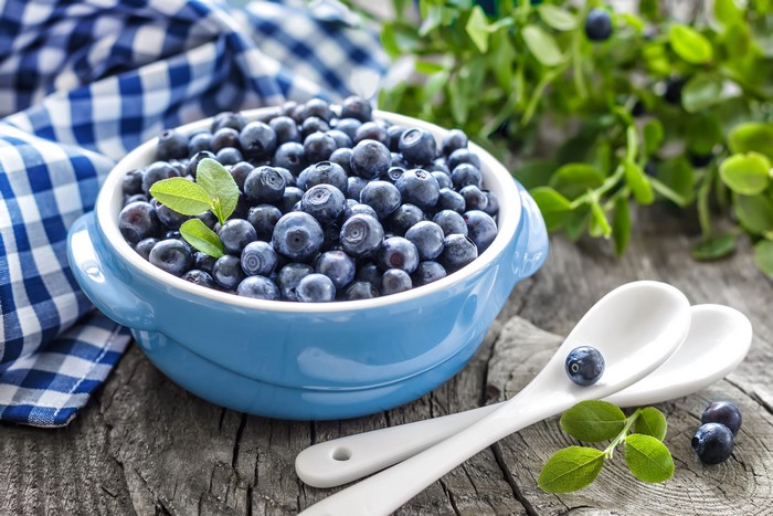 Blueberries in a blue bowl with spoons