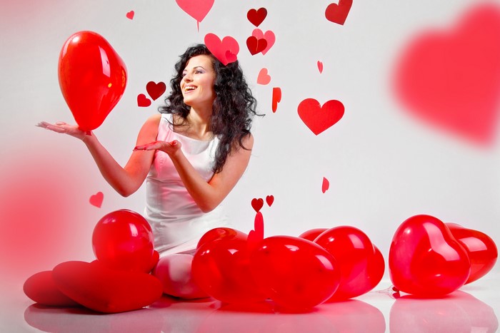 Brunette girl with red heart balloons and hearts