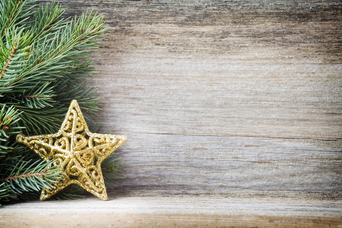 Christmas Fir Branches and Golden Star on Wood