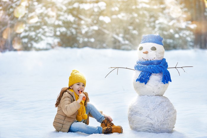 Girl with Snowman in Winter Forest