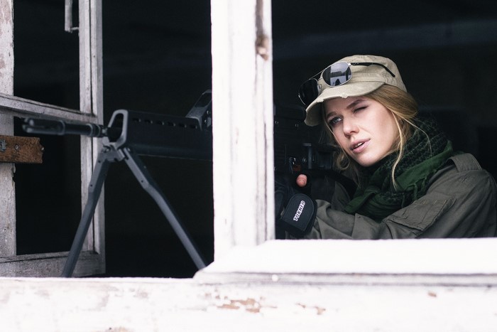 Woman in military attire with a rifle