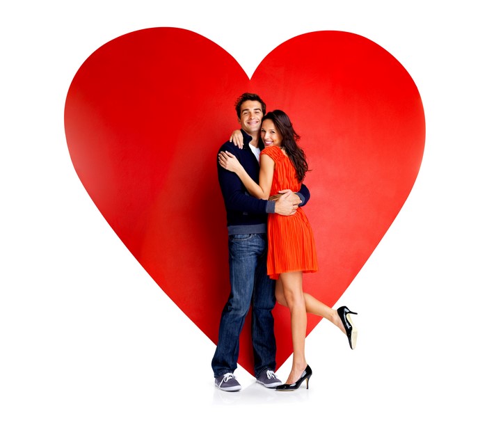 Couple hugging in front of a large red heart
