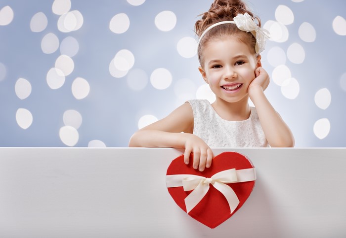 Little girl with heart gift box