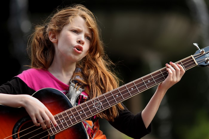 Young Girl Passionately Playing Guitar Outdoors