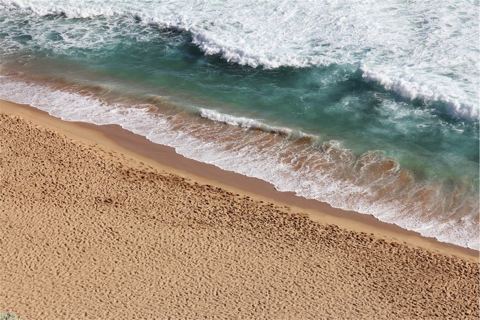Ocean waves crashing on a sandy beach