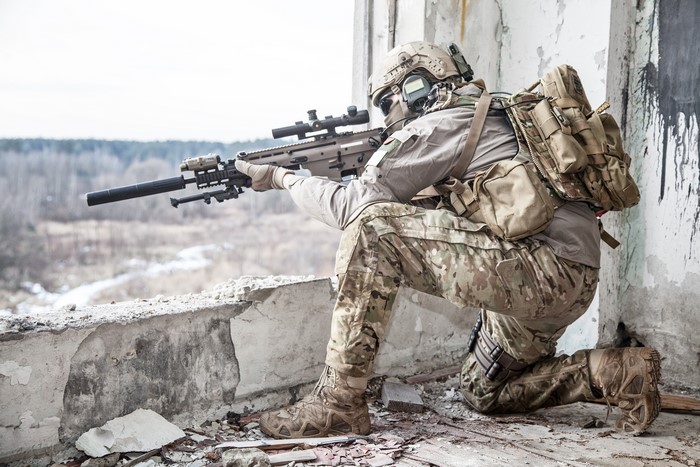 Soldier aiming a sniper rifle from a ruined building