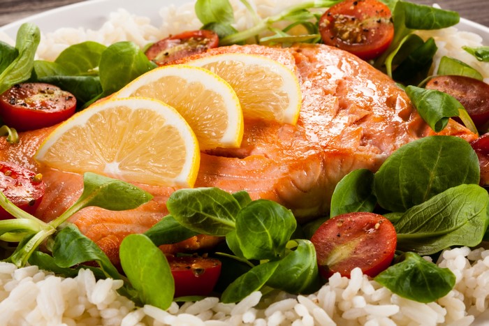 Salmon with rice, lemon, and cherry tomatoes