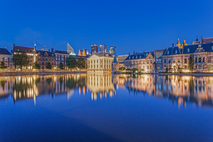 Binnenhof complex reflected in Hofvijver pond at dusk, The Hague
