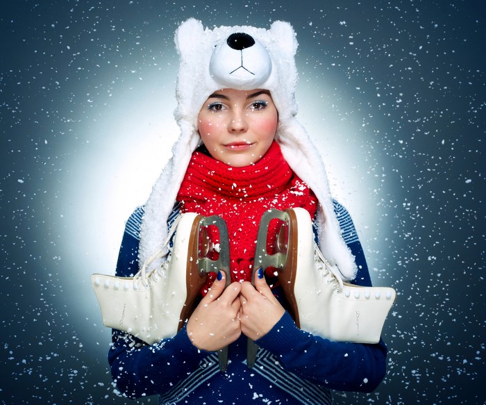 Woman in polar bear hat holding ice skates