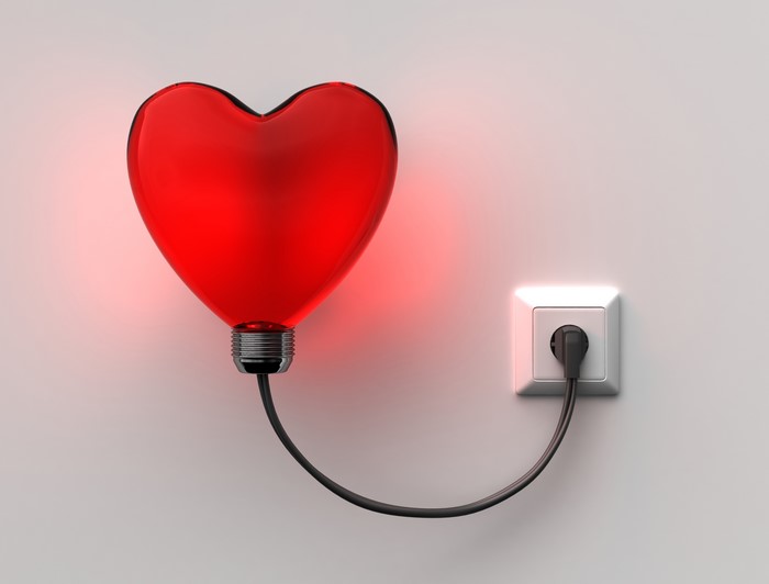 Red Heart Lightbulb Plugged into Wall Socket