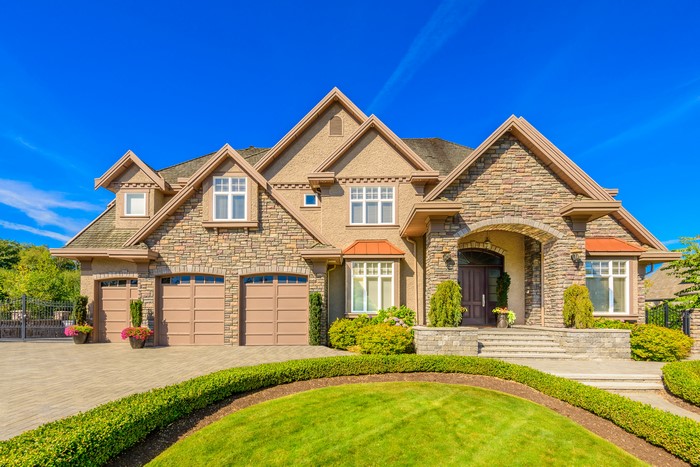 Luxury Mansion with Stone Facade and Manicured Lawn