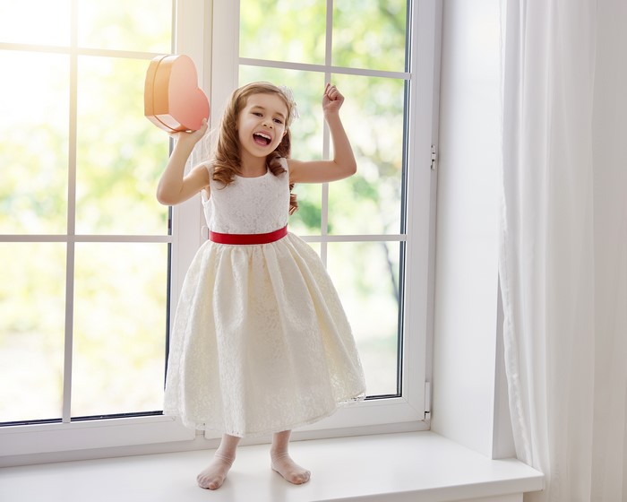 Girl in a white dress holding a heart-shaped box