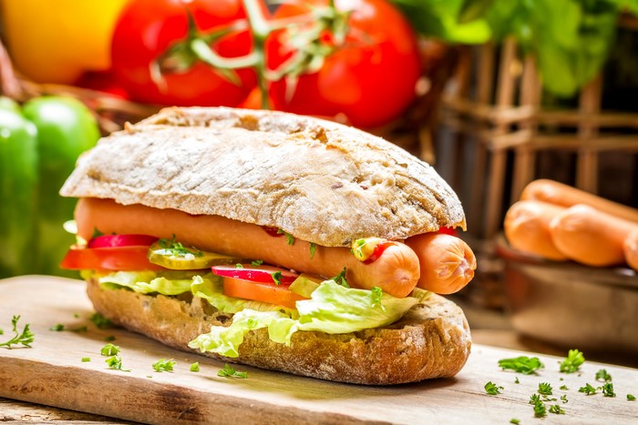 Hot dog with vegetables in a bun