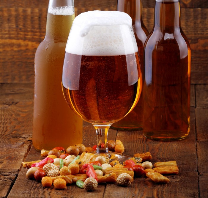 Beer in a glass and bottles with snacks