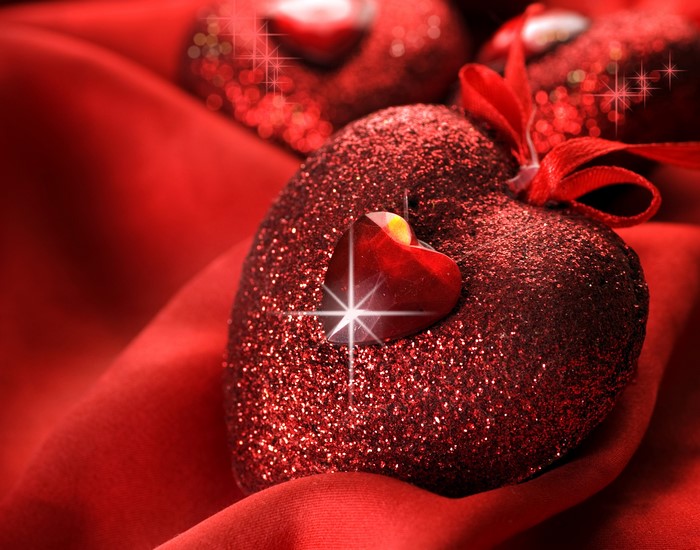 Glittering red hearts on red satin