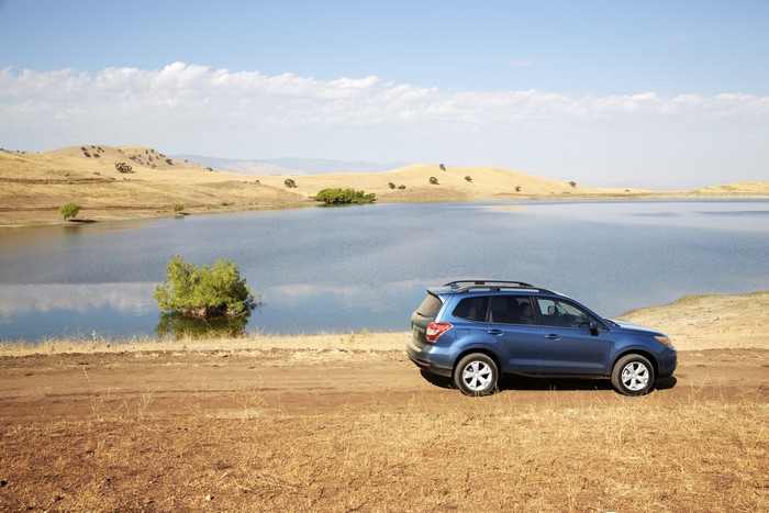 Blue Subaru Forester parked by a lake