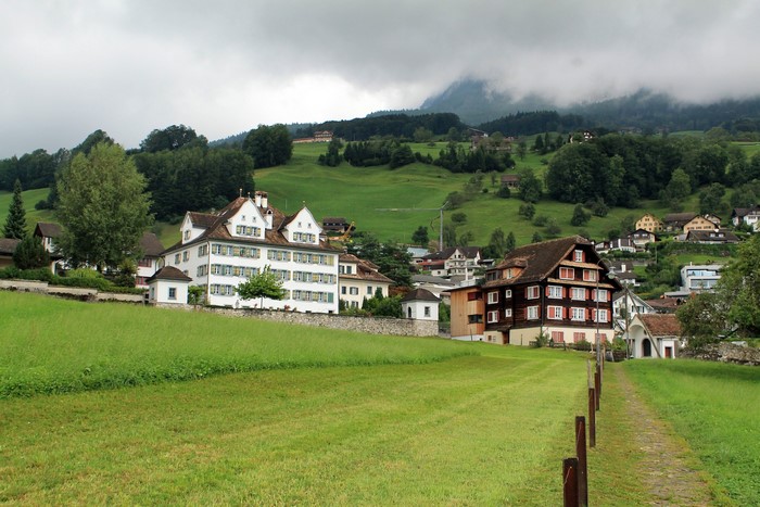 Houses in Schwyz, Switzerland with Mountains and Grasslands
