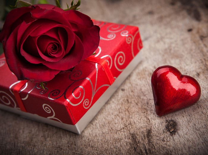 Red rose on gift box with heart