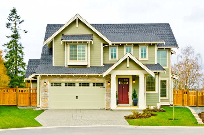 Green two-story house with a garage and red door