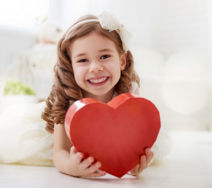 Little girl holding a red heart