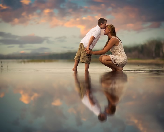 Mother and son in water at sunset
