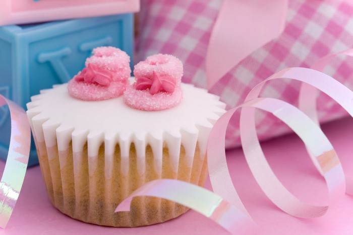 Cupcake with baby booties and ribbon