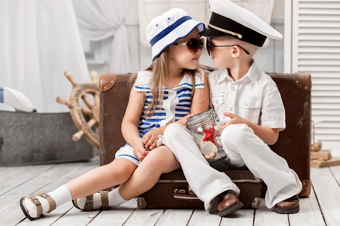 Children in sailor outfits with a suitcase