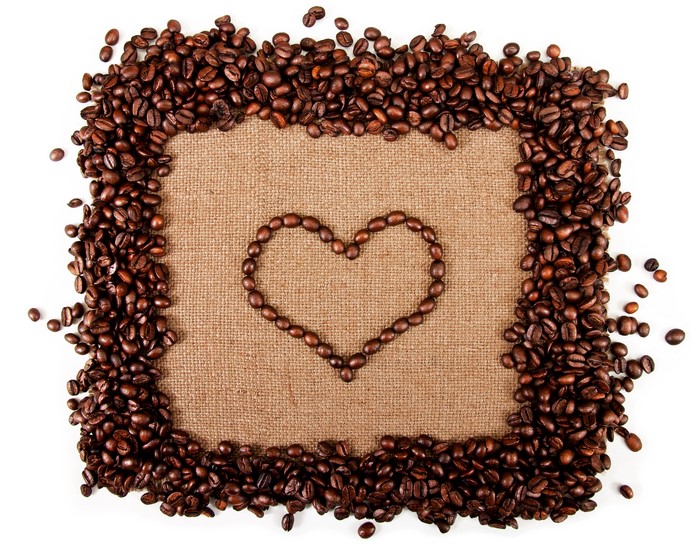 Coffee beans arranged in a heart shape on burlap