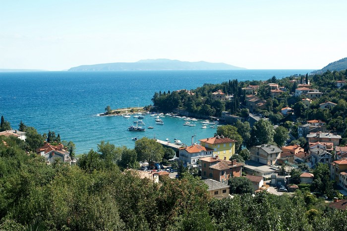Coastal town with boats in a bay and distant mountains
