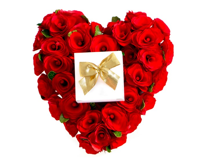 Heart shape made of red roses with a gift box