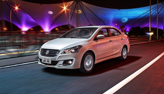 White Suzuki Alivio driving at night