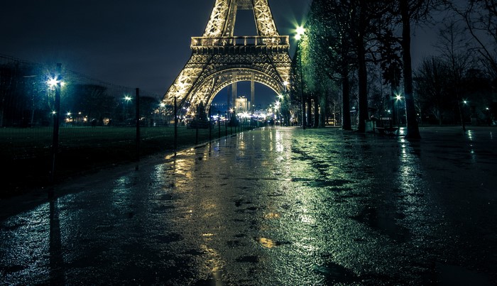 Eiffel Tower at night with wet path and street lights