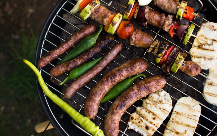 Sausages, skewers, and halloumi on a barbecue grill