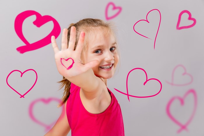 Girl with hearts drawn on her hand and around her