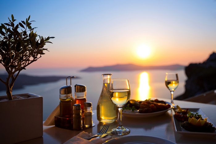 Table setting with wine and food at sunset