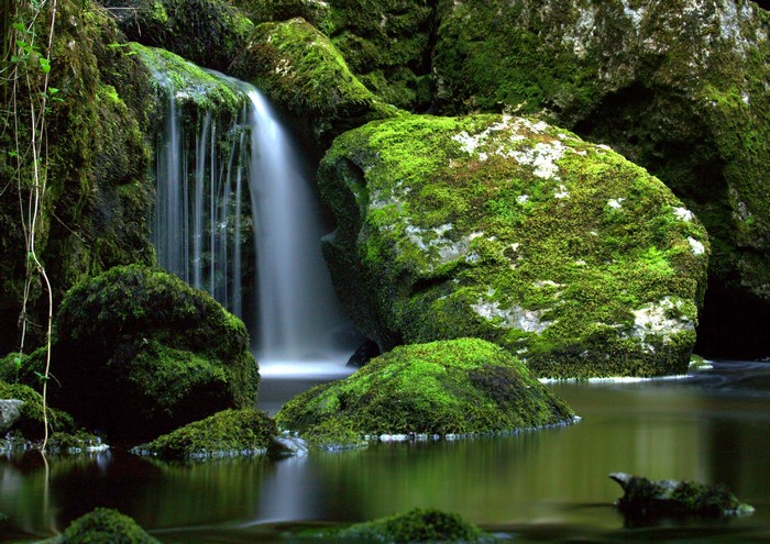 Waterfall cascading over moss-covered rocks in a river