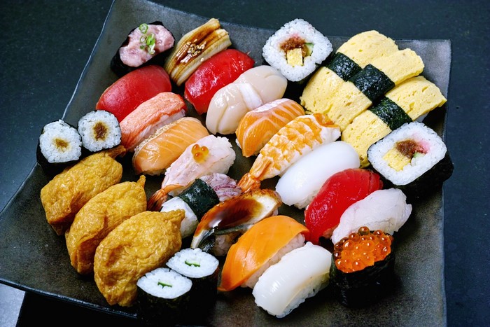 Assortment of sushi and sashimi on a black plate