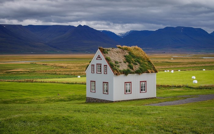 Sod house in Icelandic grasslands with mountains