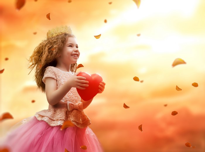 Little girl in princess dress holding a heart