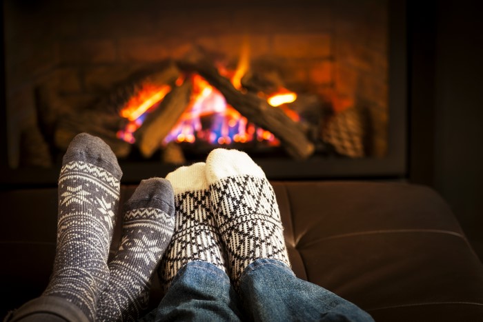 Feet in patterned socks by a fireplace