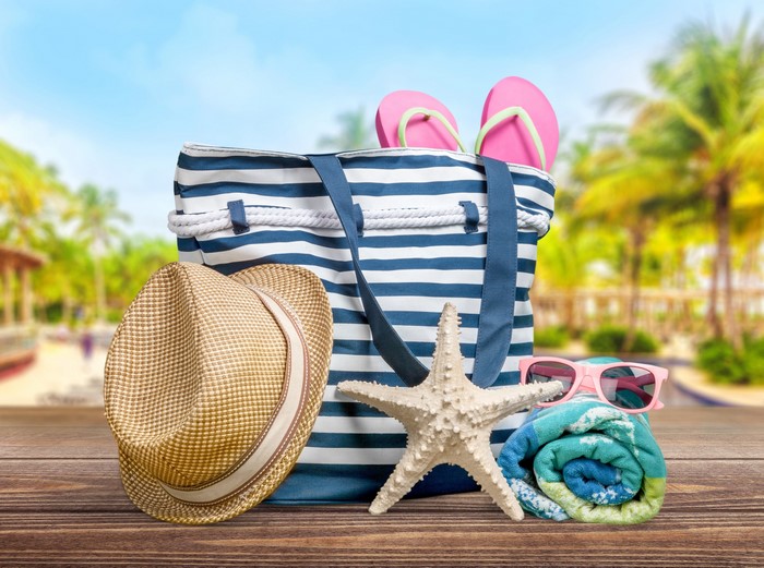 Beach bag with hat, starfish, sunglasses, and flip-flops