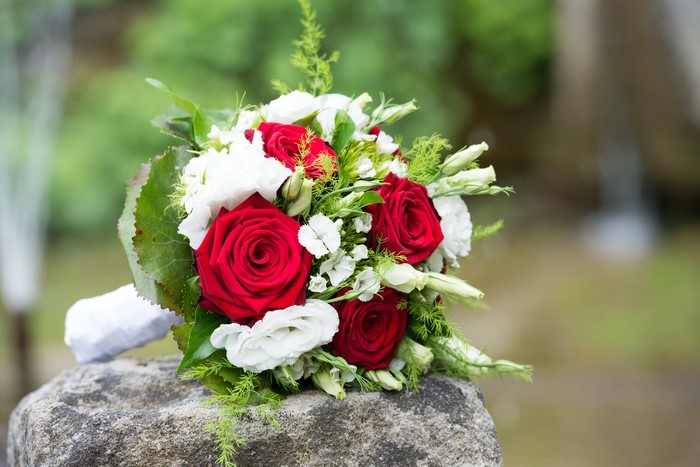 Bouquet of red roses and white eustoma on a stone
