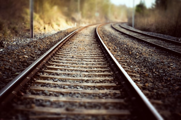 Railroad tracks curving through a wooded area