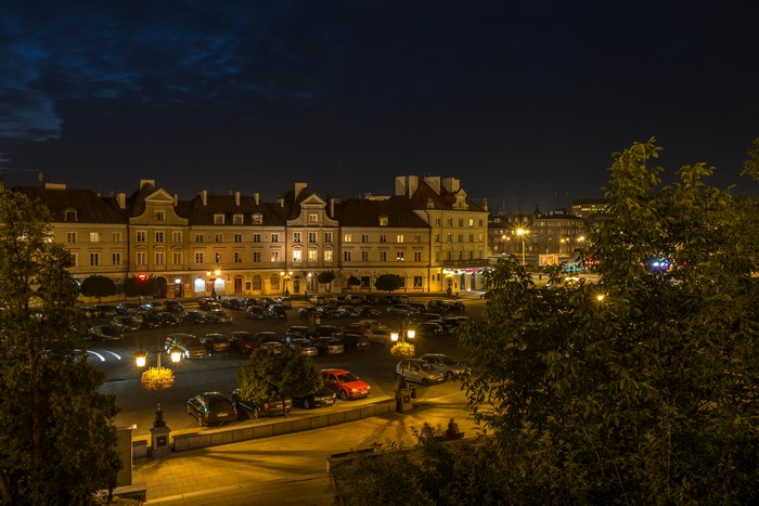 Night view of Lublin, Poland with illuminated buildings and parked cars