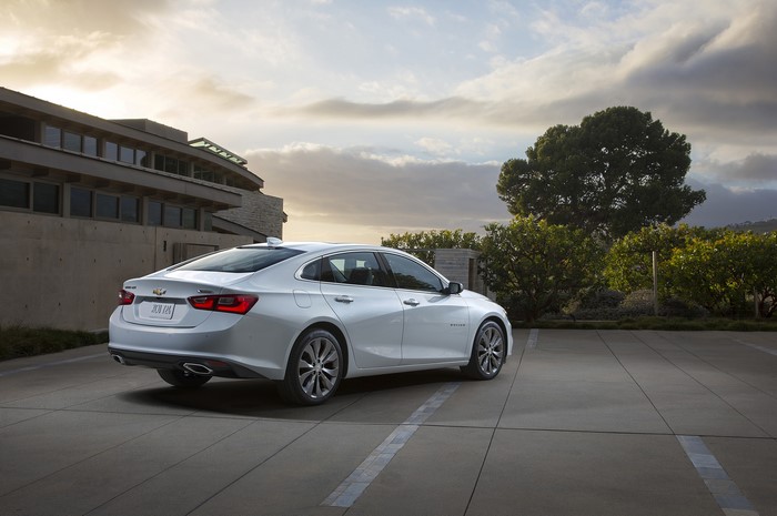 Silver Chevrolet Malibu parked in front of a modern building