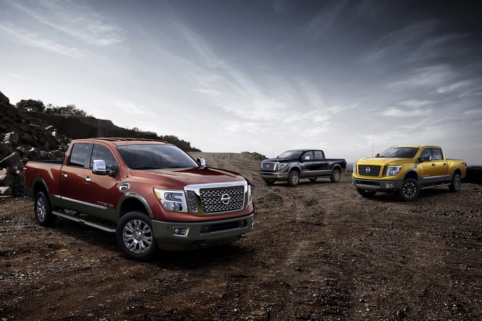 Three Nissan Titan XD trucks in a rocky landscape
