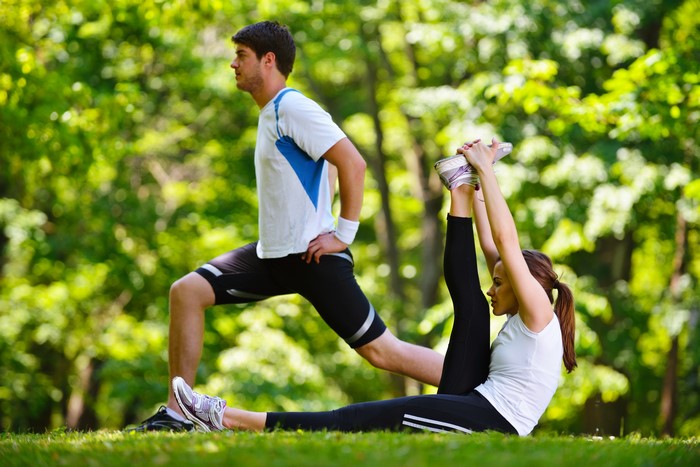 Man and woman stretching in a park