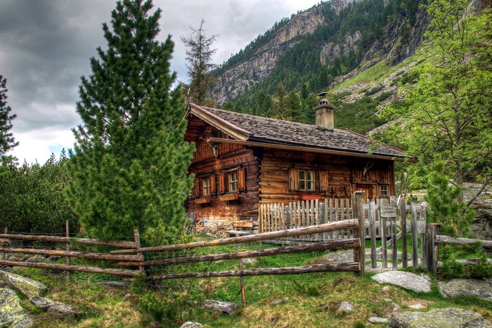 Wooden cabin in the Austrian Alps with a fence