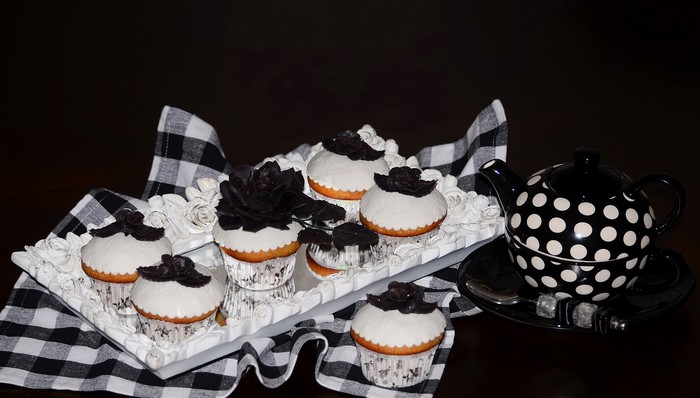 Black and white polka dot teapot with cupcakes on a tray