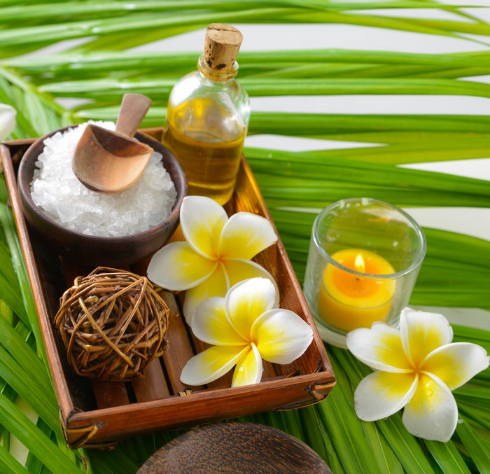 Spa setting with Plumeria flowers, salt, oil, and candle